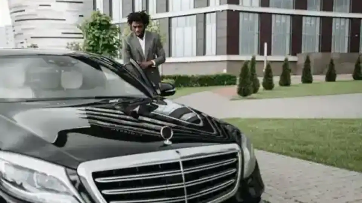 Chauffeur professionnel devant une berline premium — sélection Mozio