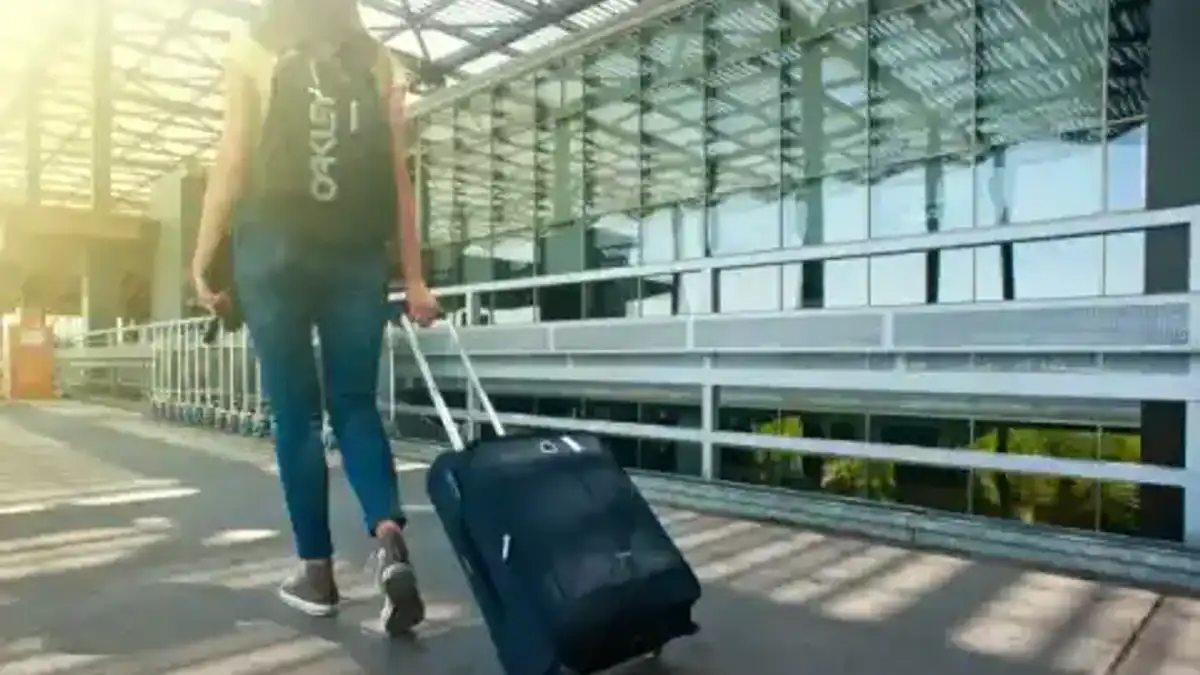 Voyageuse avec bagage devant un terminal aéroportuaire — sélection Shuttle Direct